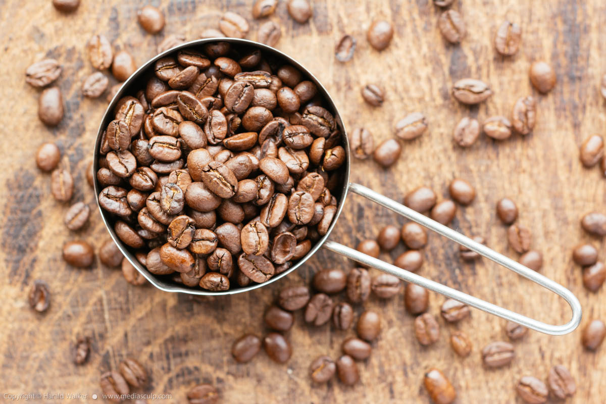 Stock photo of Measuring cup of coffee beans