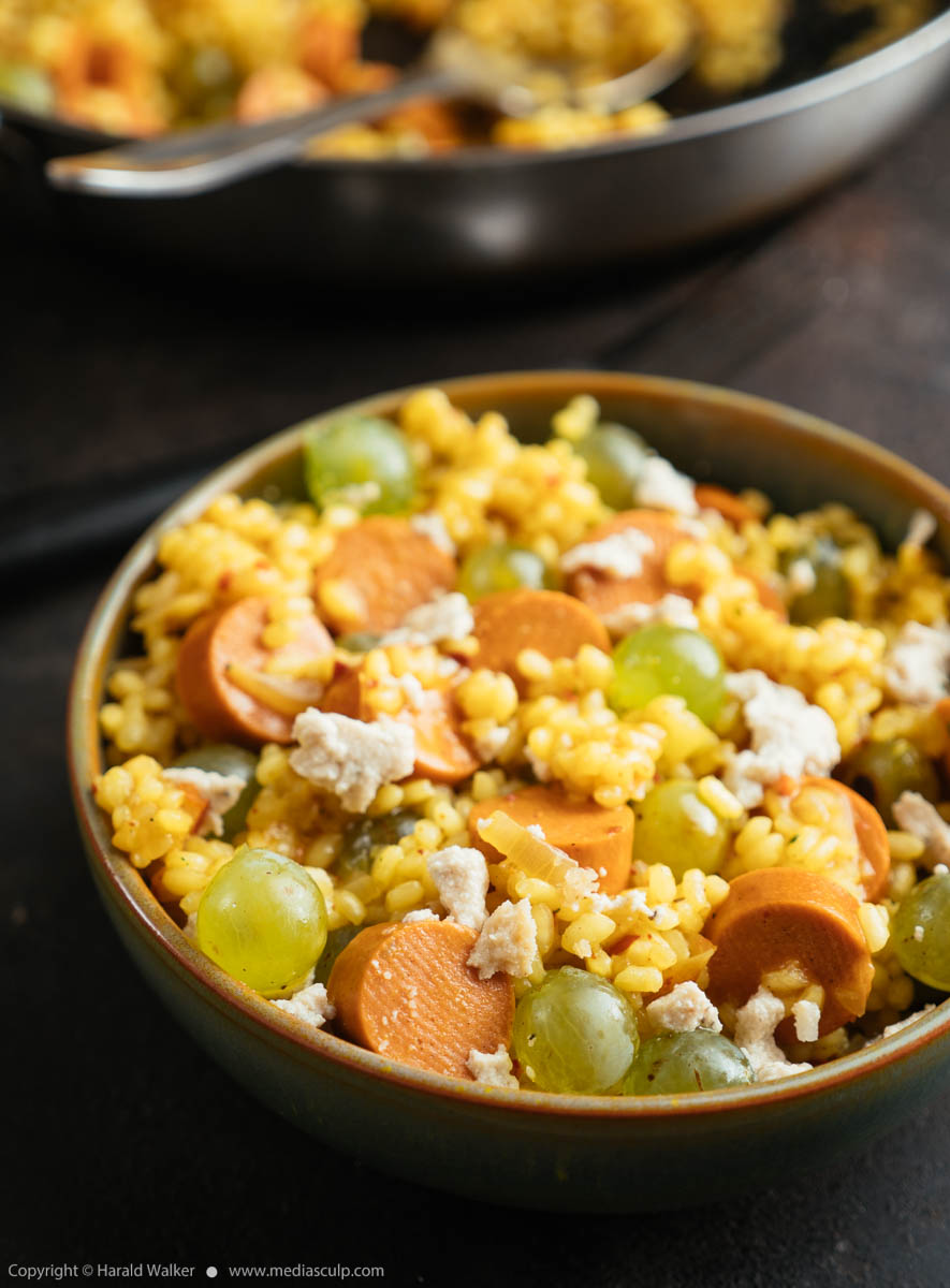 Stock photo of Grape Risotto with Vegan Hot Dogs and Feta