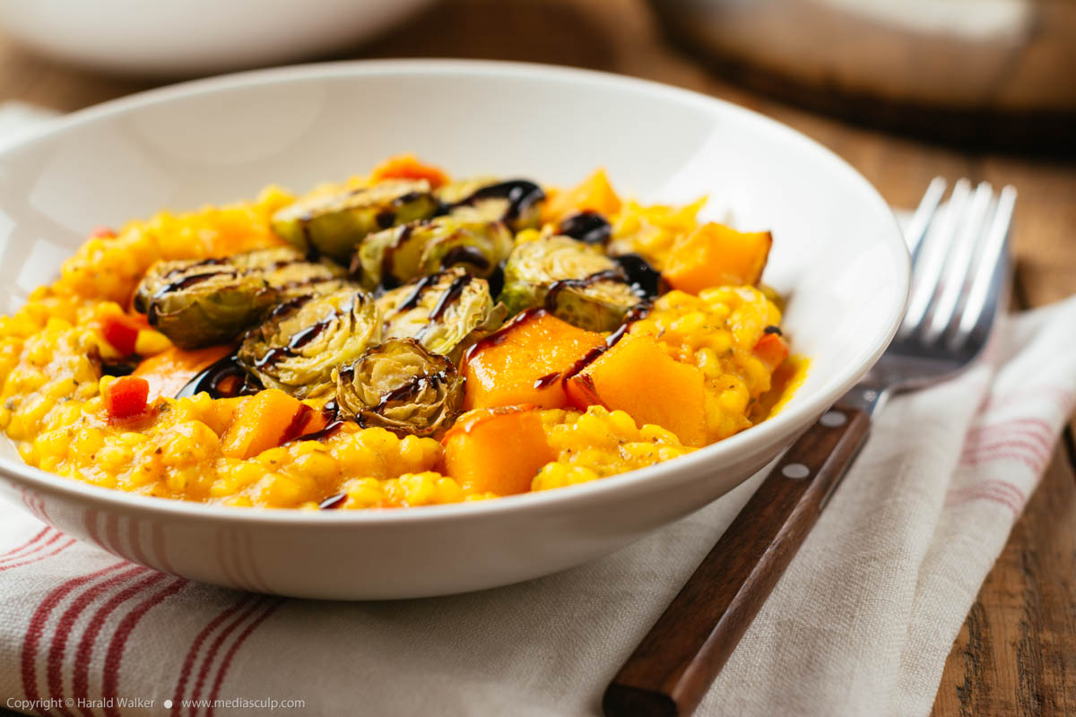 Stock photo of Squash Risotto with Roasted Brussels Sprouts and Balsamic Vinegar Reduction
