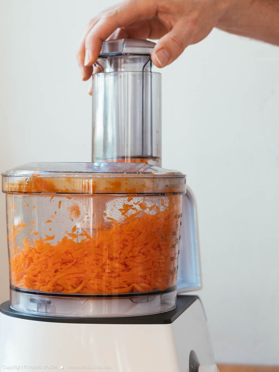 Stock photo of Grating a carrot in a food processor